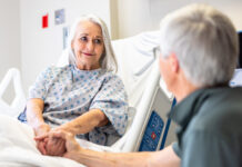 Scripting Out “The Talk” – What To Tell Your Medical Power of Attorney Agent A senior woman in the hospital room recovering, while her husband supports her.